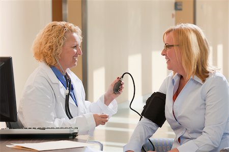 simsearch:6105-05397029,k - Female doctor measuring a patient's blood pressure Foto de stock - Royalty Free Premium, Número: 6105-05397049