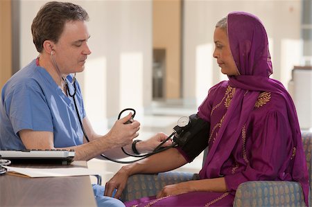 esfigmomanómetro - Male nurse measuring a patient's blood pressure Foto de stock - Sin royalties Premium, Código: 6105-05397051