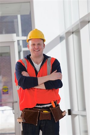 engineer standing with arms crossed - Portrait d'un ingénieur en construction souriant Photographie de stock - Premium Libres de Droits, Code: 6105-05397063