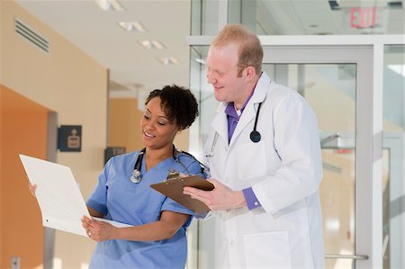 simsearch:6105-05397029,k - Male doctor discussing a medical report with a female nurse Foto de stock - Royalty Free Premium, Número: 6105-05397019