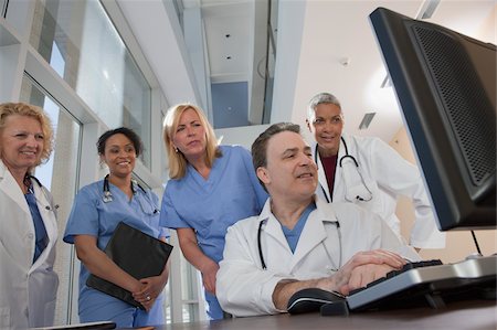 doctors group smiling - Doctors and nurses consulting on a computer in hospital Stock Photo - Premium Royalty-Free, Code: 6105-05397039