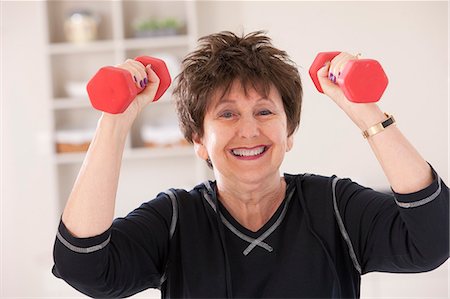 Portrait of a woman exercising with dumbbells in a health club Stock Photo - Premium Royalty-Free, Code: 6105-05397167