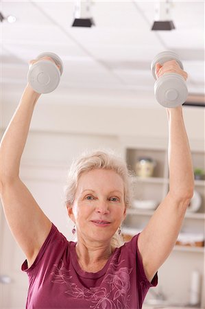 Portrait of a woman exercising with dumbbells in a health club Stock Photo - Premium Royalty-Free, Code: 6105-05397168