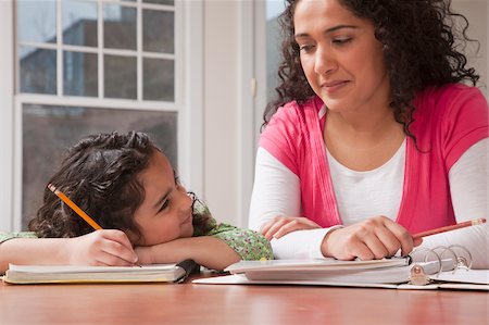 smiling mixed race mother and daughter - Hispanic woman assisting her daughter while doing homework Stock Photo - Premium Royalty-Free, Code: 6105-05397190