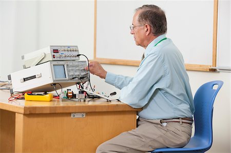 electric current - Professor adjusting oscilloscope triggering level in electronics classroom Stock Photo - Premium Royalty-Free, Code: 6105-05953706
