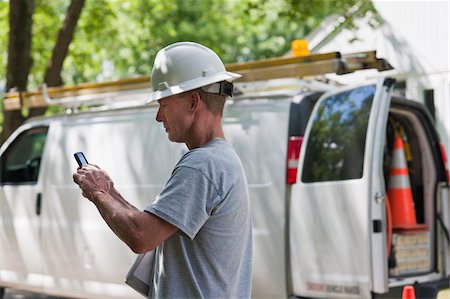 electric pylon - Cable installer reviewing work order for installation on smartphone Foto de stock - Sin royalties Premium, Código: 6105-05953733