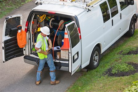 simsearch:6105-07521269,k - Communications worker preparing to climb pole at his truck Stock Photo - Premium Royalty-Free, Code: 6105-05953737