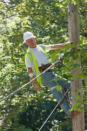 Lineman on a pole working on phone and cable wires Foto de stock - Sin royalties Premium, Código: 6105-05953739