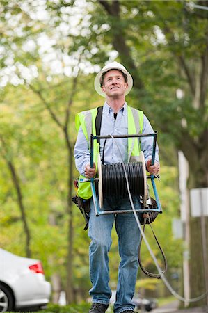 powerline worker - Cable installer unwinding reel of cable Stock Photo - Premium Royalty-Free, Code: 6105-06042940