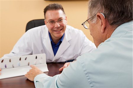 Patient choosing hearing aid color with an audiologist Stock Photo - Premium Royalty-Free, Code: 6105-06042965