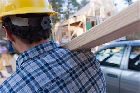 Carpenter carrying a rafter for house under construction Stock Photo - Premium Royalty-Free, Code: 6105-06042995