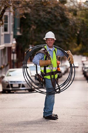 Cable installer carrying video cables on a street Stock Photo - Premium Royalty-Free, Code: 6105-06042934