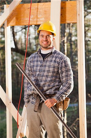 simsearch:6105-06043027,k - Portrait of a carpenter holding a level on house framing Stock Photo - Premium Royalty-Free, Code: 6105-06043042