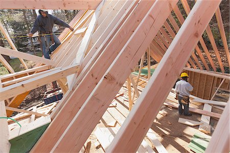 dormer frame construction - Carpenter measuring house dormer Stock Photo - Premium Royalty-Free, Code: 6105-06043054