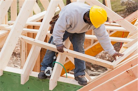 dormer frame construction - Carpenter placing a rafter for dormer Stock Photo - Premium Royalty-Free, Code: 6105-06043063