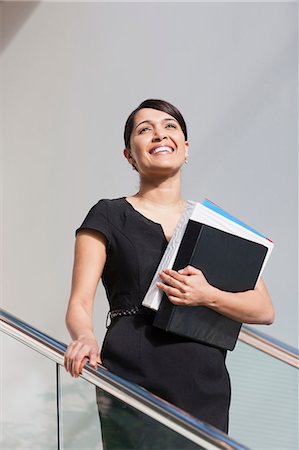 simsearch:6105-06043104,k - Businesswoman holding folders on stairs of office building Stock Photo - Premium Royalty-Free, Code: 6105-06043098