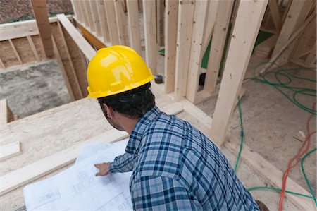 planning for a house - Carpenter reviewing house plans Stock Photo - Premium Royalty-Free, Code: 6105-06043000