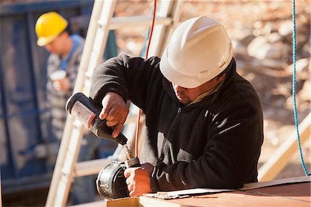 Carpenter lubricating nail gun Stock Photo - Premium Royalty-Free, Code: 6105-06043015