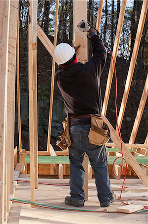 Carpenter nailing a temporary brace in place Stock Photo - Premium Royalty-Free, Code: 6105-06043032