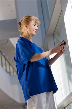 Nurse text messaging on her smartphone Stock Photo - Premium Royalty-Free, Code: 6105-06043117