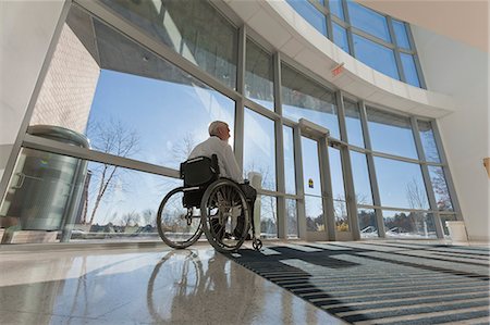 Doctor with muscular dystrophy in wheelchair at hospital entrance Stock Photo - Premium Royalty-Free, Code: 6105-06043128