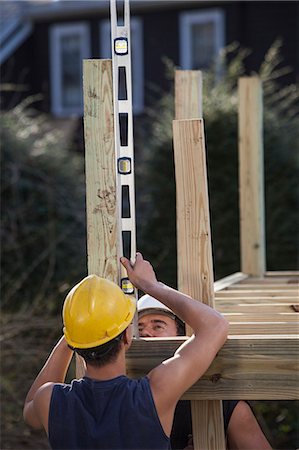 simsearch:6105-06702892,k - Hispanic carpenters using a level on deck post construction Stock Photo - Premium Royalty-Free, Code: 6105-06702887