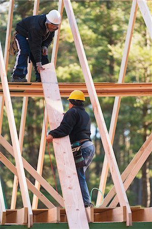 simsearch:6105-07521418,k - Carpenters moving rafter into place Fotografie stock - Premium Royalty-Free, Codice: 6105-06702835