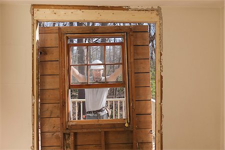 simsearch:6105-06702940,k - Hispanic carpenter removing newly cut door access to deck on home Stock Photo - Premium Royalty-Free, Code: 6105-06702950