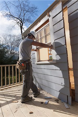 Hispanic carpenter removing newly cut door access to deck on home Photographie de stock - Premium Libres de Droits, Code: 6105-06702952