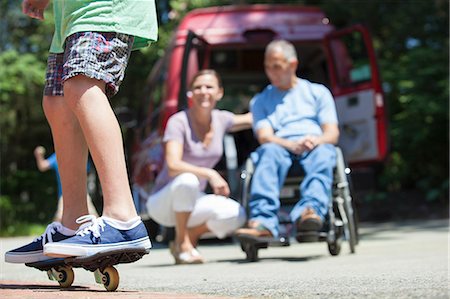 female wheelchair woman - Couple watching his son on skate board Stock Photo - Premium Royalty-Free, Code: 6105-06702998