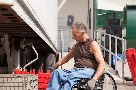 simsearch:6105-05396581,k - Loading dock worker with spinal cord injury in a wheelchair stacking inventory trays Photographie de stock - Premium Libres de Droits, Code: 6105-06703057