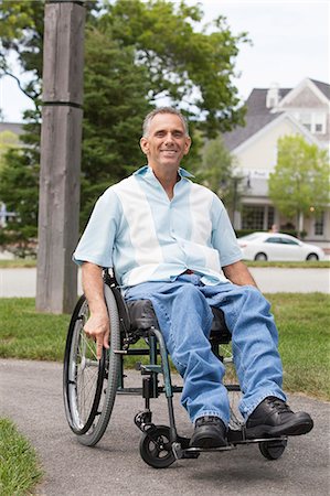 Man with spinal cord injury in a wheelchair enjoying outdoors Stock Photo - Premium Royalty-Free, Code: 6105-06703055