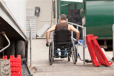 dock worker pictures - Loading dock worker with spinal cord injury in a wheelchair going up ramp beside a truck Photographie de stock - Premium Libres de Droits, Code: 6105-06703056