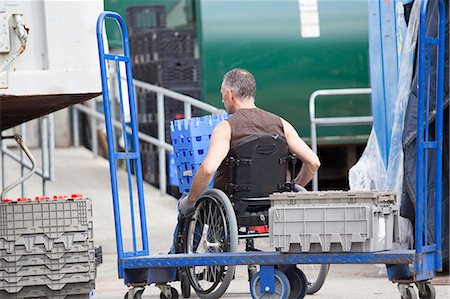 simsearch:6105-05396334,k - Loading dock worker with spinal cord injury in a wheelchair moving stacked inventory trays Stockbilder - Premium RF Lizenzfrei, Bildnummer: 6105-06703063