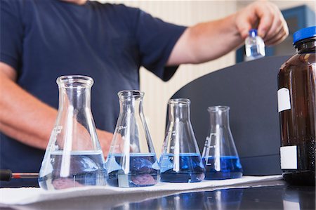 Engineer with sample bottles of indigo solution and ozonated water and vial in hand for analysis in water treatment plant Foto de stock - Sin royalties Premium, Código: 6105-06703115