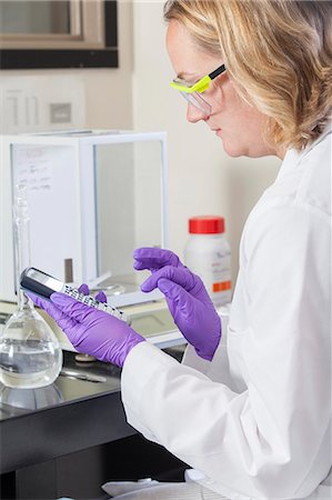 erlenmeyer flask and beaker - Laboratory scientist doing calculations for chemical analysis Photographie de stock - Premium Libres de Droits, Code: 6105-06703125