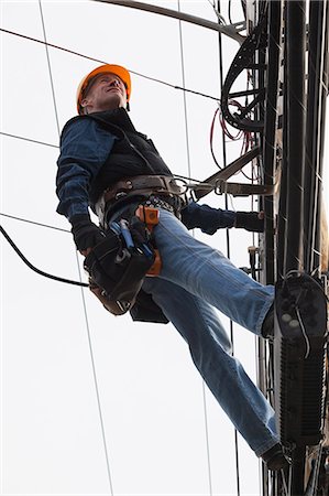 fil électrique - Communications worker examining cables on power pole Photographie de stock - Premium Libres de Droits, Code: 6105-07521249