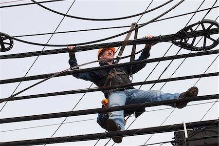 Communications worker adding cables to a bundle Stock Photo - Premium Royalty-Free, Code: 6105-07521253