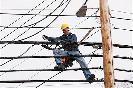 simsearch:6105-07521389,k - Communications worker using a wrench on cable support attachments Photographie de stock - Premium Libres de Droits, Code: 6105-07521251