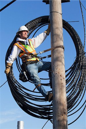 simsearch:6105-05396608,k - Cable lineman preparing to install new cable from power pole Photographie de stock - Premium Libres de Droits, Code: 6105-07521276