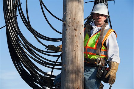 pylon - Cable lineman on a power pole with new bundle of cable Stock Photo - Premium Royalty-Free, Code: 6105-07521279