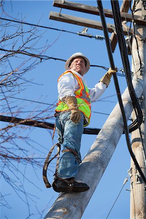 fil électrique - Cable lineman climbing a pole brace to cable bundles on power pole Photographie de stock - Premium Libres de Droits, Code: 6105-07521280
