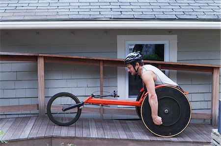 Man with spinal cord injury in disability racing bike Foto de stock - Royalty Free Premium, Número: 6105-07521220