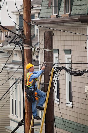 Cable lineman installing a filter on city power poles Foto de stock - Sin royalties Premium, Código: 6105-07521237