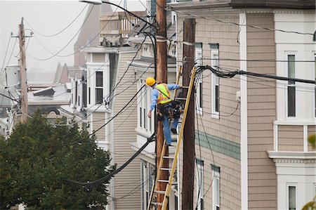 simsearch:6118-07440218,k - Cable lineman assessing cable distribution wiring on poles in the city Foto de stock - Sin royalties Premium, Código: 6105-07521238