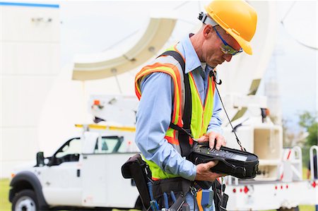 Communications engineer preparing measuring instrument for satellite antenna alignment Stock Photo - Premium Royalty-Free, Code: 6105-07521442