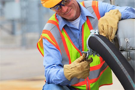 simsearch:6105-07744436,k - Electrical engineer inspecting hose connection for cooling supply lines at power plant Stock Photo - Premium Royalty-Free, Code: 6105-07521450