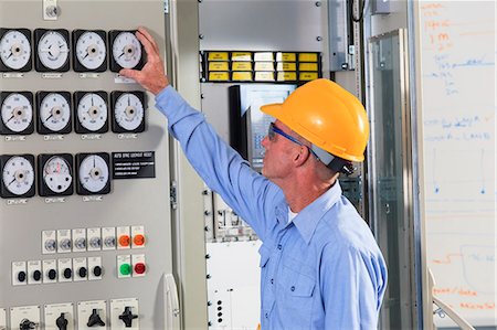 power station control - Electrical engineer inspecting power plant controls in central operations room of power plant Foto de stock - Sin royalties Premium, Código: 6105-07521463