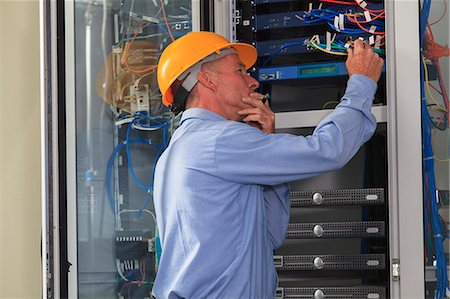 simsearch:6105-07521406,k - Electrical engineer working with switches and servers in broadband communication hub of electric power plant Stock Photo - Premium Royalty-Free, Code: 6105-07521460