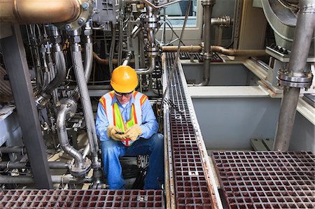 Engineer working on gas turbine which drives generators in power plant while turbine is powered down Photographie de stock - Premium Libres de Droits, Code: 6105-07521469